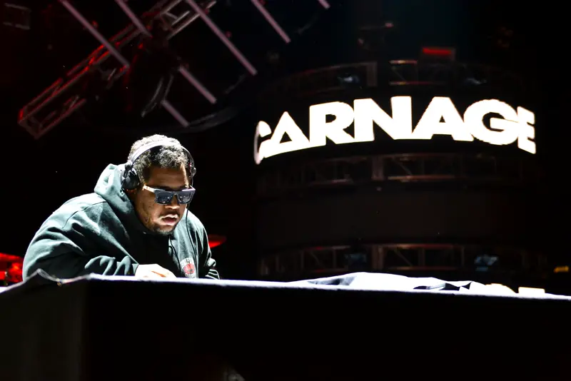 DJ at the decks in front of a giant LED wall