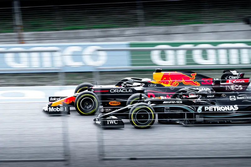 Two Formula 1 cars side by side at speed, panning shot